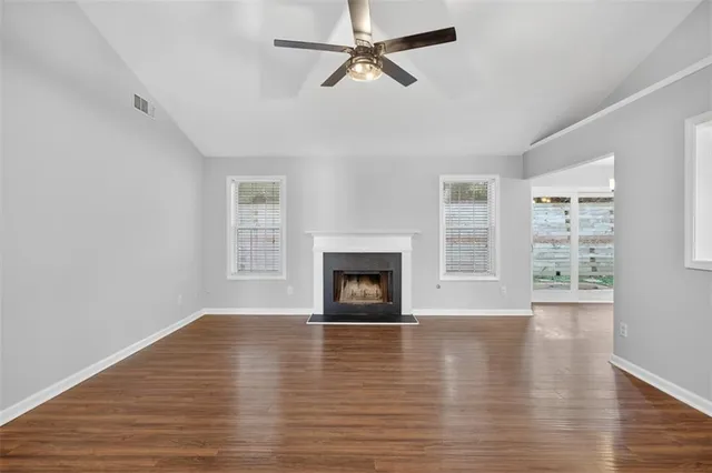 wooden floor fireplace and windows in an empty room
