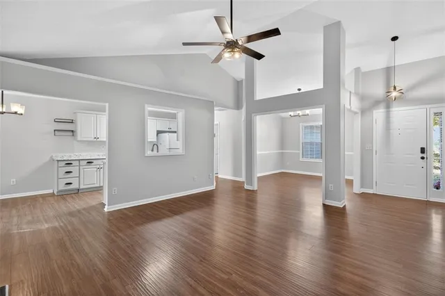 a view of an empty room with a window and wooden floor