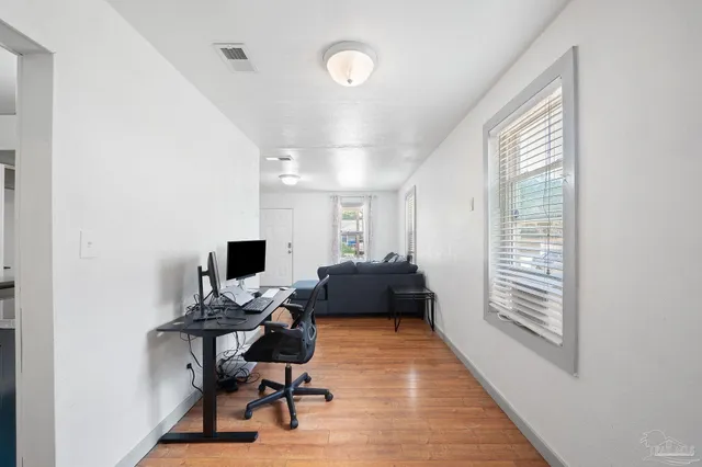 a living room with furniture and a wooden floor