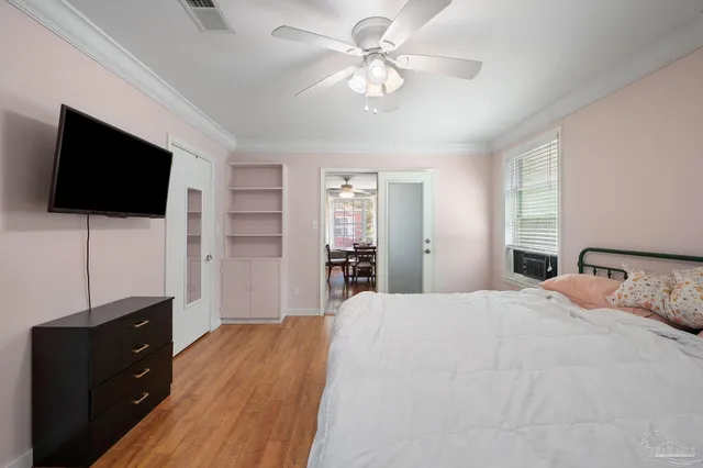 a bedroom with a large bed wooden floor and window
