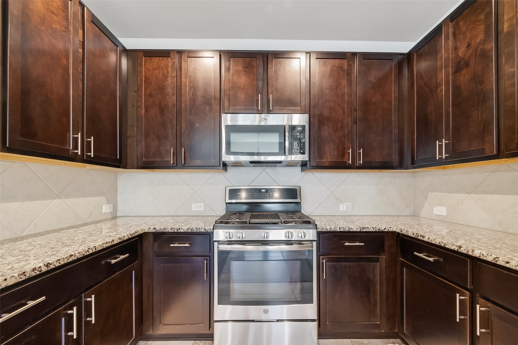 8630 Willet Street Baytown, TX 77521 - Photo 11 of 48 a kitchen with granite countertop wood cabinets and stainless steel appliances