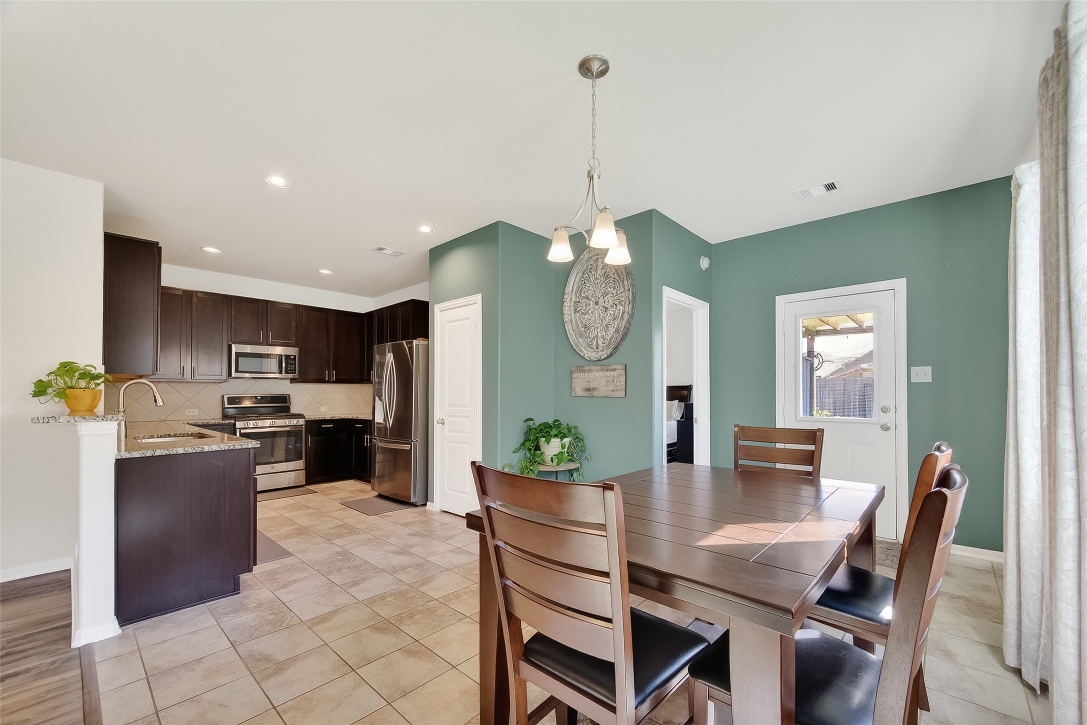 8630 Willet Street Baytown, TX 77521 - Photo 15 of 48 a view of a dining room and a kitchen with a table chairs