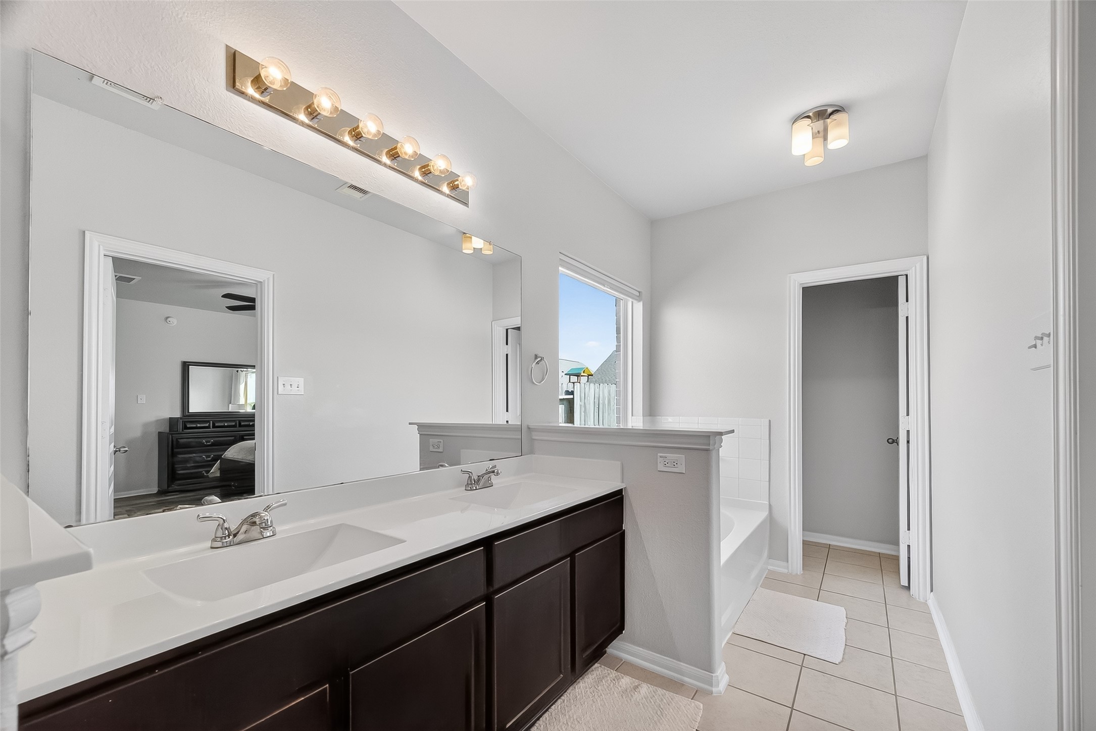 8630 Willet Street Baytown, TX 77521 - Photo 41 of 48 a en suite bathroom with a double vanity sink and a mirror