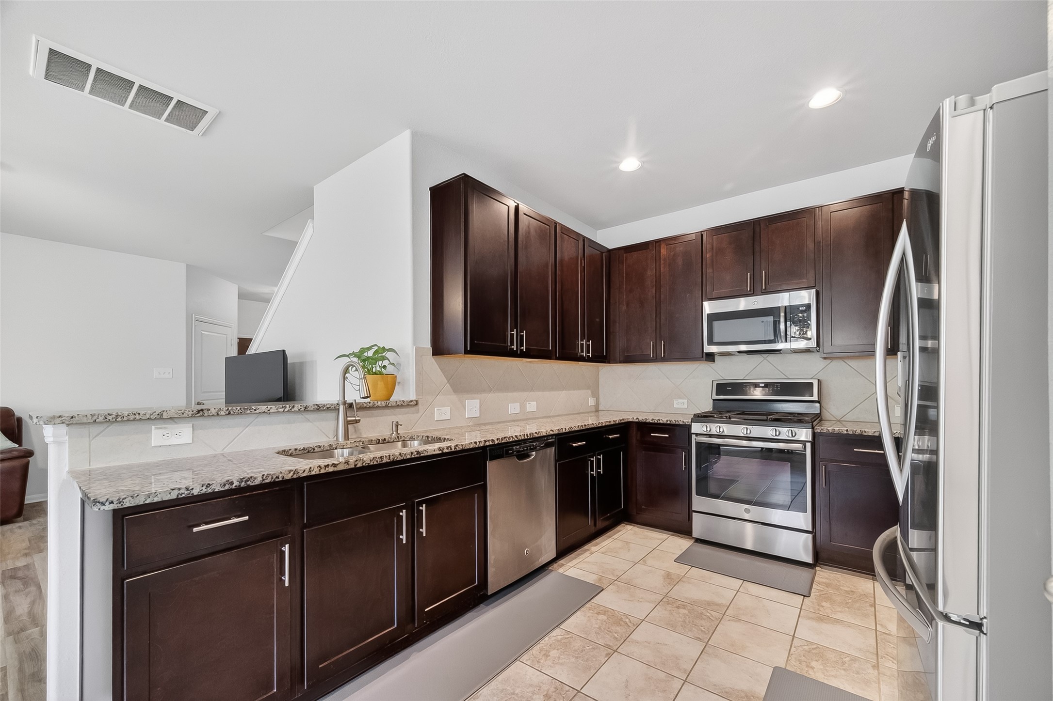 8630 Willet Street Baytown, TX 77521 - Photo 10 of 48 a kitchen with stainless steel appliances granite countertop a sink stove refrigerator and cabinets