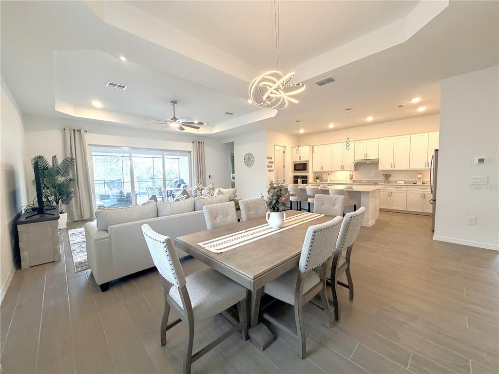 13081 Tulum Loop Venice, FL 34293 - Photo 10 of 48 a dining room with kitchen island furniture a large window and appliances