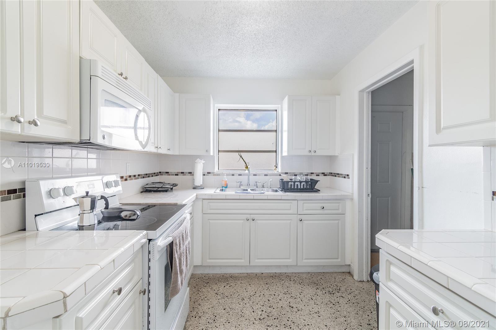 Hialeah Acres Hialeah, FL 33010 - Photo 15 of 45 a kitchen with granite countertop a sink stove and cabinets