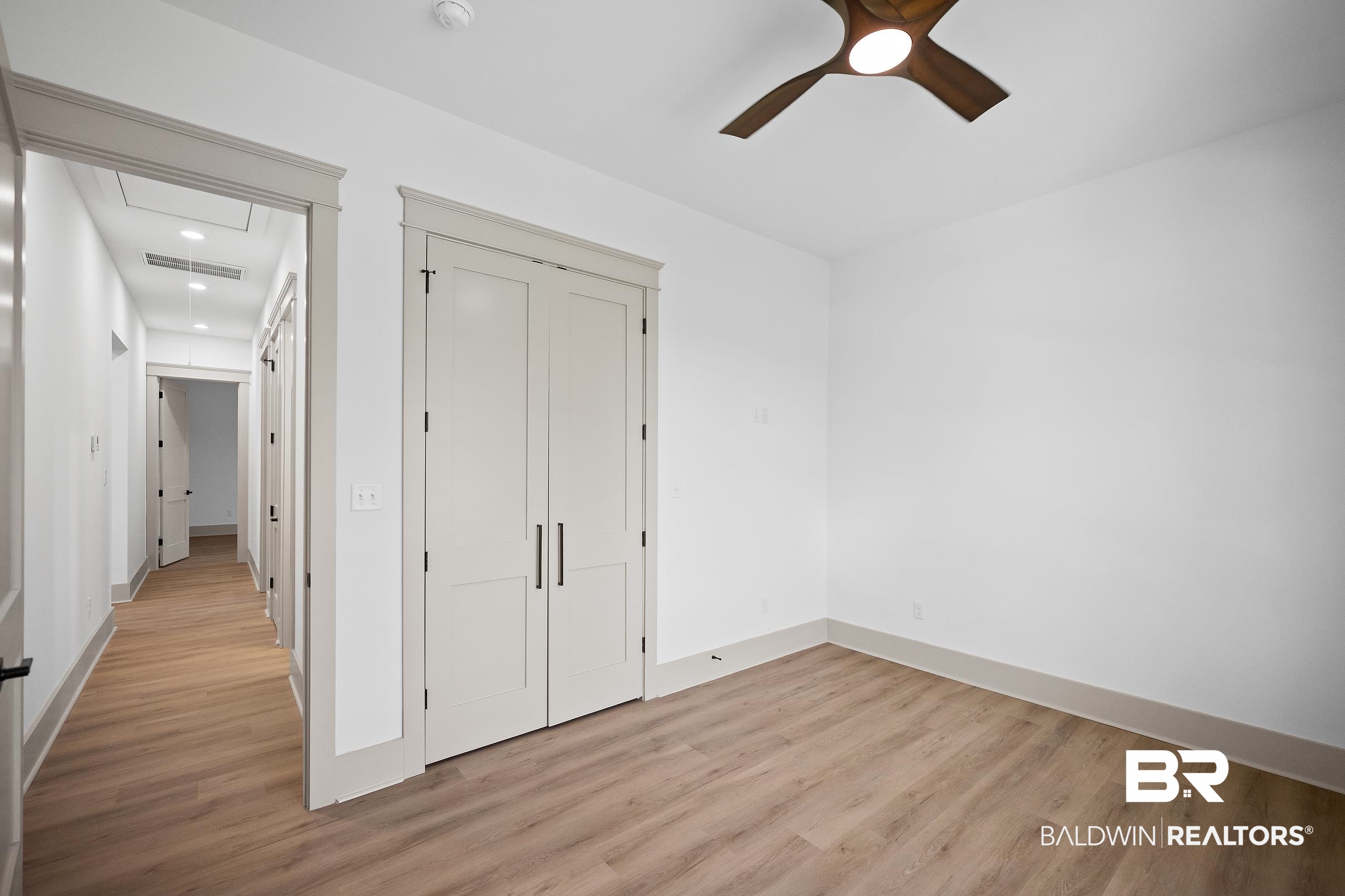 13111 Gopher Court Elberta, AL 36530 - Photo 29 of 41 Room featuring wood-finish flooring, white walls, and a contemporary ceiling fan with integrated lighting