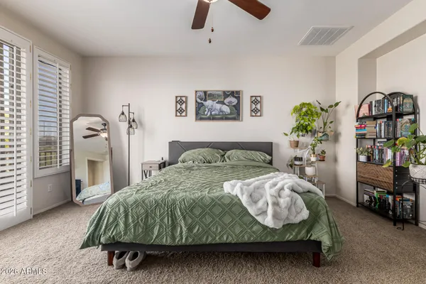 a bedroom with a bed table and a window