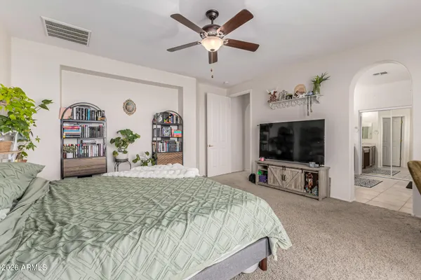 a bedroom with a bed and a flat tv screen on dresser