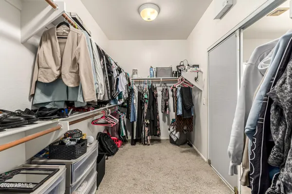 a view of walk in closet with clothes and shoes