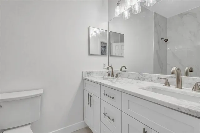 a bathroom with a toilet a sink a tub and mirror