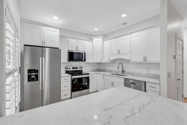 a kitchen with a refrigerator stove microwave and sink