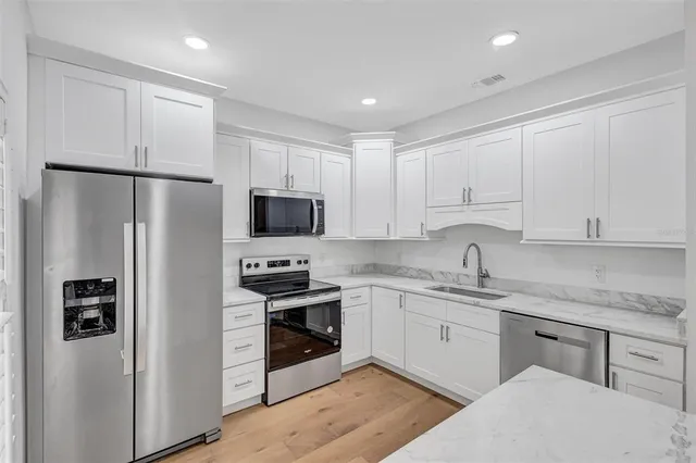 a kitchen with stainless steel appliances granite countertop a refrigerator sink and stove
