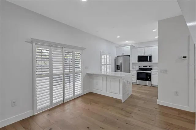 a kitchen with white cabinets and appliances