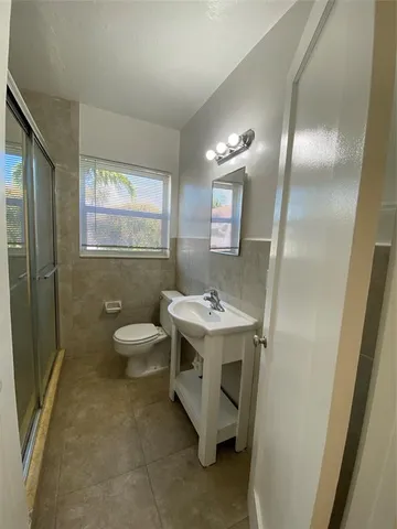 a spacious bathroom with a granite countertop sink toilet and shower