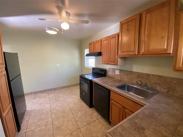 a kitchen with stainless steel appliances granite countertop a sink stove and cabinets