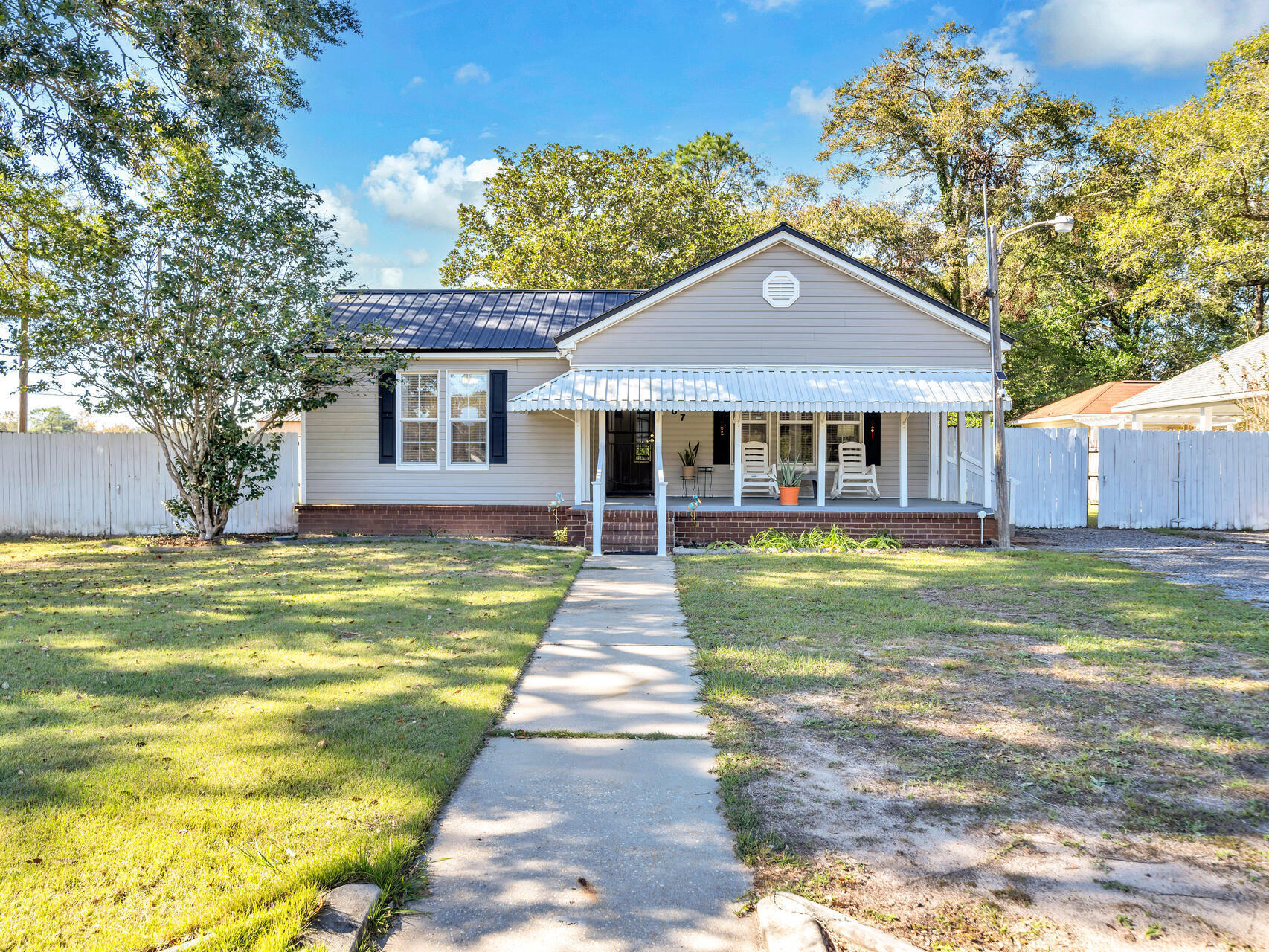 607 Alabama Street Crestview, FL 32536 - Photo 1 of 31 a front view of a house with a yard table and chairs