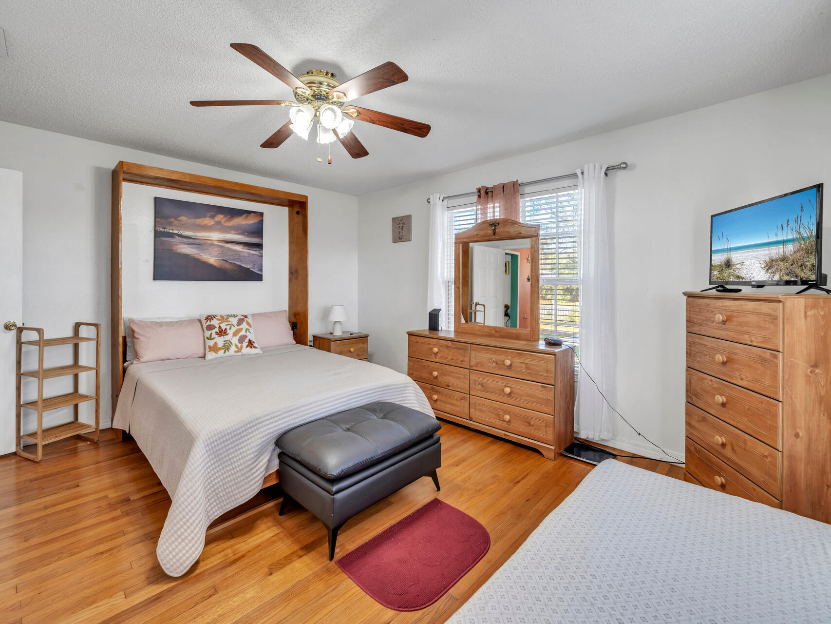 607 Alabama Street Crestview, FL 32536 - Photo 14 of 31 a bedroom with a bed and a dresser with wooden floor