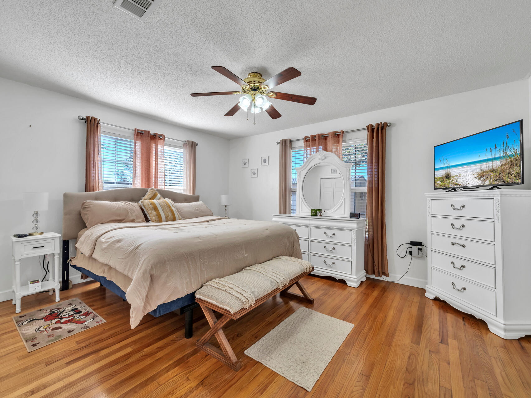 607 Alabama Street Crestview, FL 32536 - Photo 16 of 31 a spacious bedroom with a bed and a chandelier