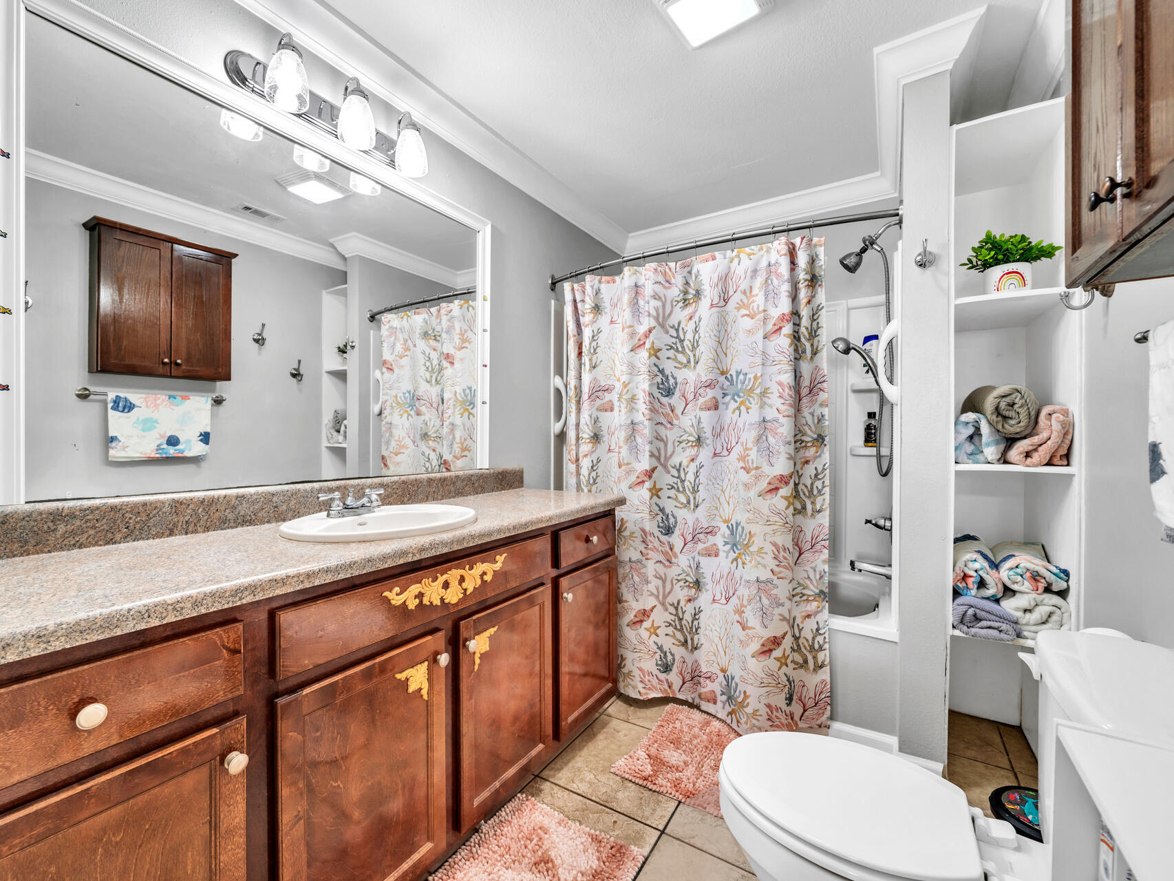 607 Alabama Street Crestview, FL 32536 - Photo 18 of 31 a bathroom with a sink a toilet a mirror and shower curtain