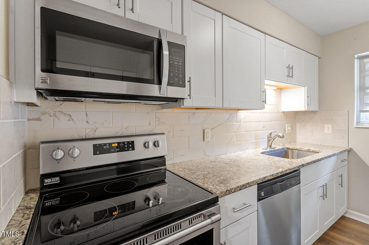 6371 New Market Way Raleigh, NC 27615 - Photo 4 of 13 a kitchen with a stove and a microwave