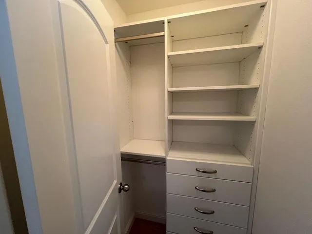 a view of walk in closet with empty racks