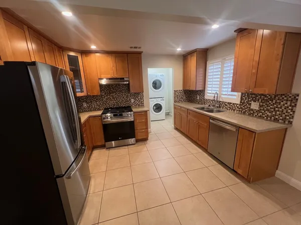 a kitchen with stainless steel appliances granite countertop a refrigerator and a stove