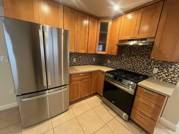 a kitchen with stainless steel appliances granite countertop a refrigerator and a stove