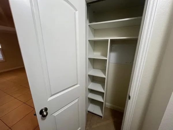 a view of walk in closet with empty racks