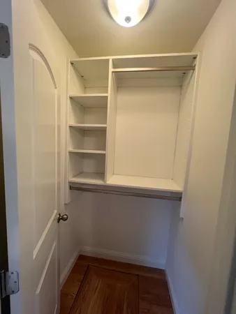 a view of walk in closet with empty racks