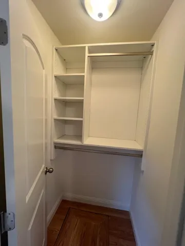a view of walk in closet with empty racks