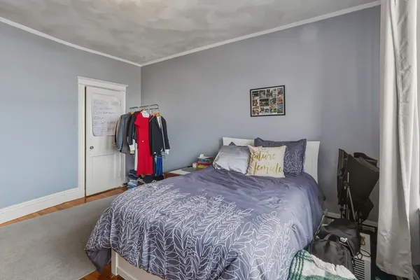 a bed sitting in a bedroom next to a window and tv