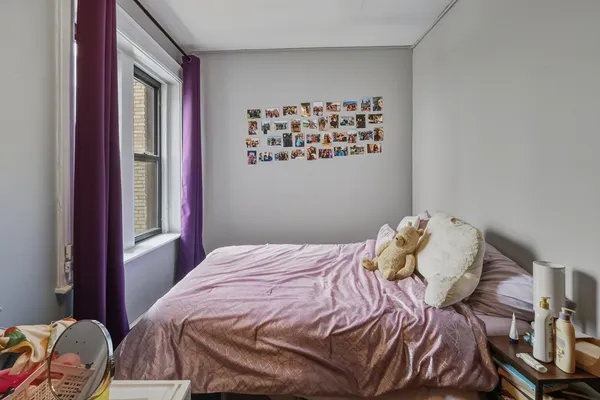 a bed sitting in a bedroom next to a window