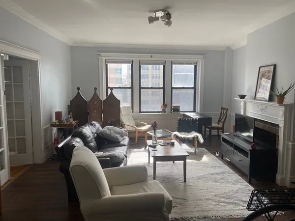 a living room with furniture fireplace and a window