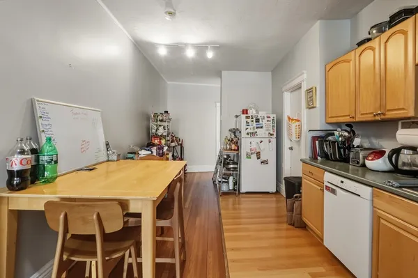 a kitchen with stainless steel appliances a stove a sink dishwasher and a refrigerator with wooden floor