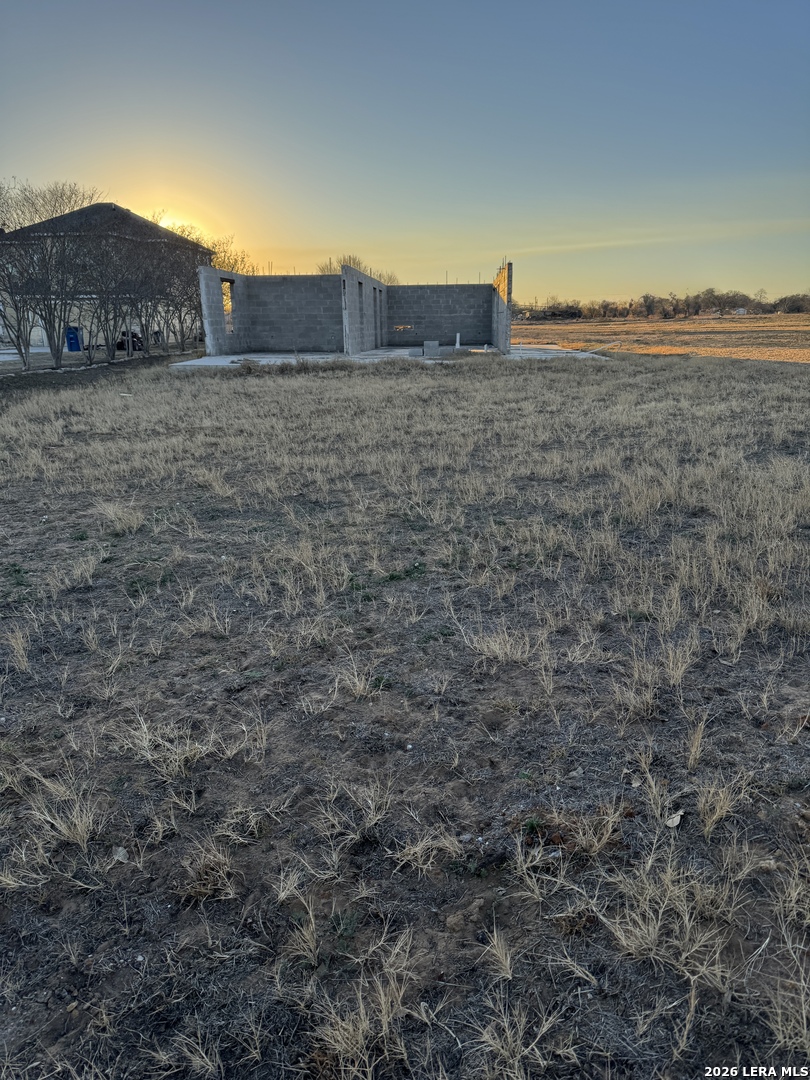 a view of a dry yard with wooden fence and a mountain view