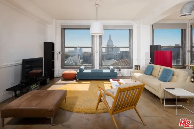 a living room with furniture a flat screen tv and a floor to ceiling window