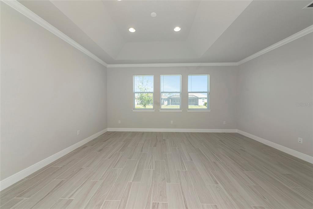 5798 Long Shore Loop Sarasota, FL 34238 - Photo 15 of 40 an empty room with wooden floor and windows