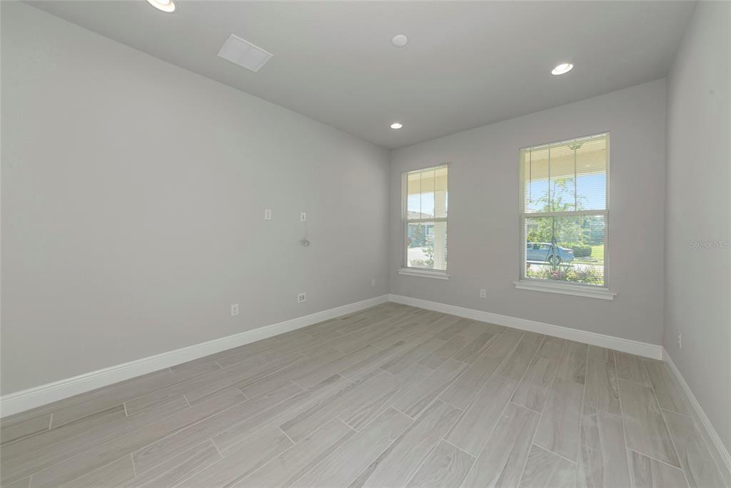 5798 Long Shore Loop Sarasota, FL 34238 - Photo 22 of 40 an empty room with wooden floor and windows
