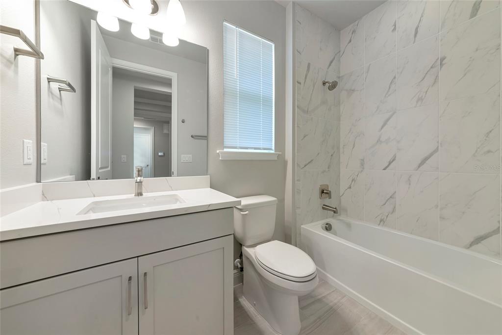 5798 Long Shore Loop Sarasota, FL 34238 - Photo 23 of 40 a bathroom with a sink toilet vanity and shower