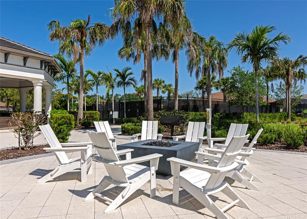 5798 Long Shore Loop Sarasota, FL 34238 - Photo 37 of 40 a view of a patio with a dining table and chairs under palm trees