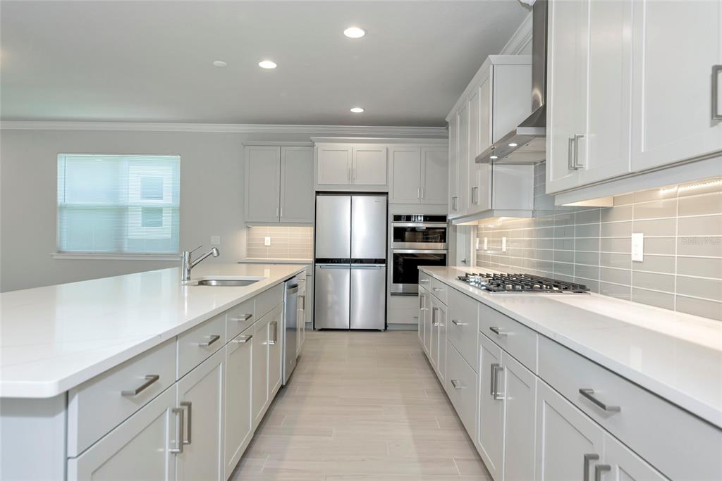 5798 Long Shore Loop Sarasota, FL 34238 - Photo 7 of 40 a kitchen with white cabinets appliances and sink