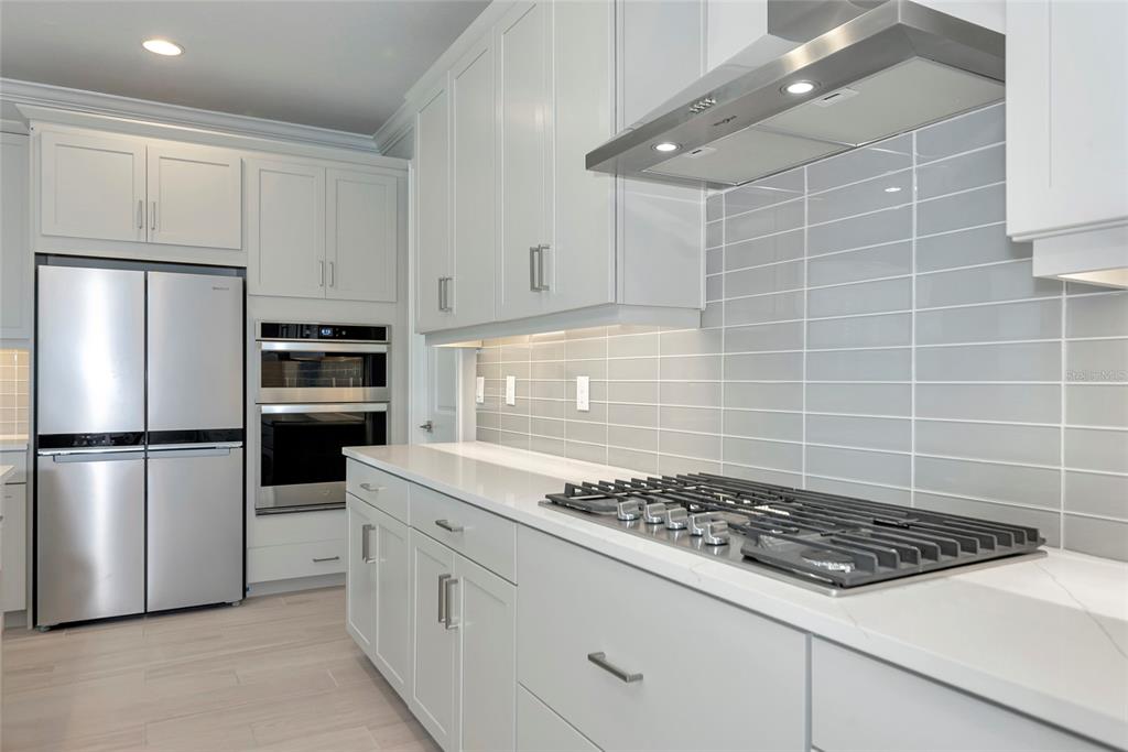 5798 Long Shore Loop Sarasota, FL 34238 - Photo 8 of 40 a kitchen with a stove a refrigerator and white cabinets