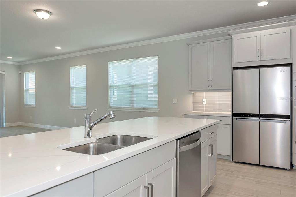 5798 Long Shore Loop Sarasota, FL 34238 - Photo 9 of 40 a kitchen with a sink a refrigerator and white cabinets