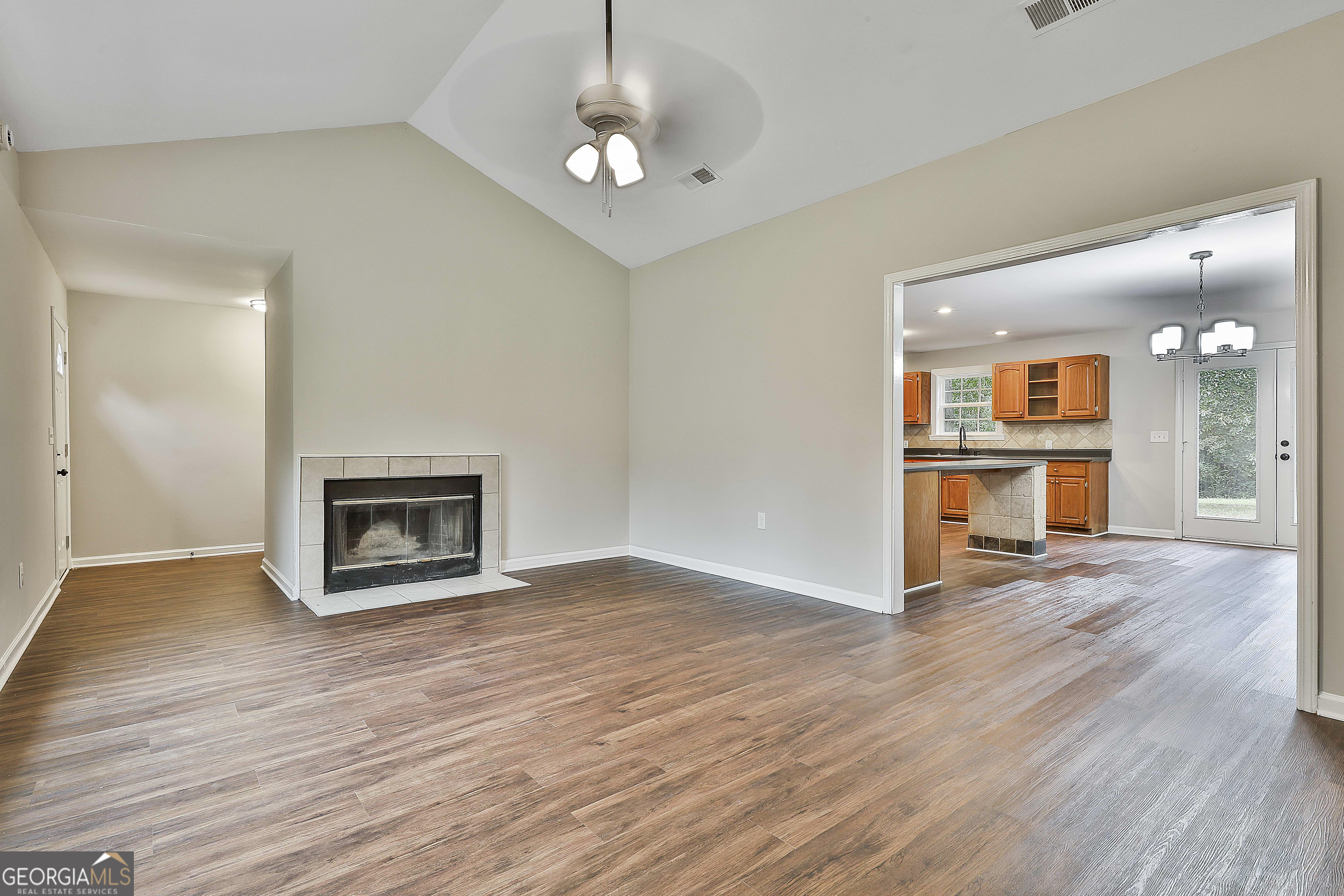 1606 Mcwilliams Barber Road Luthersville, GA 30251 - Photo 13 of 38 an empty room with wooden floor and kitchen view