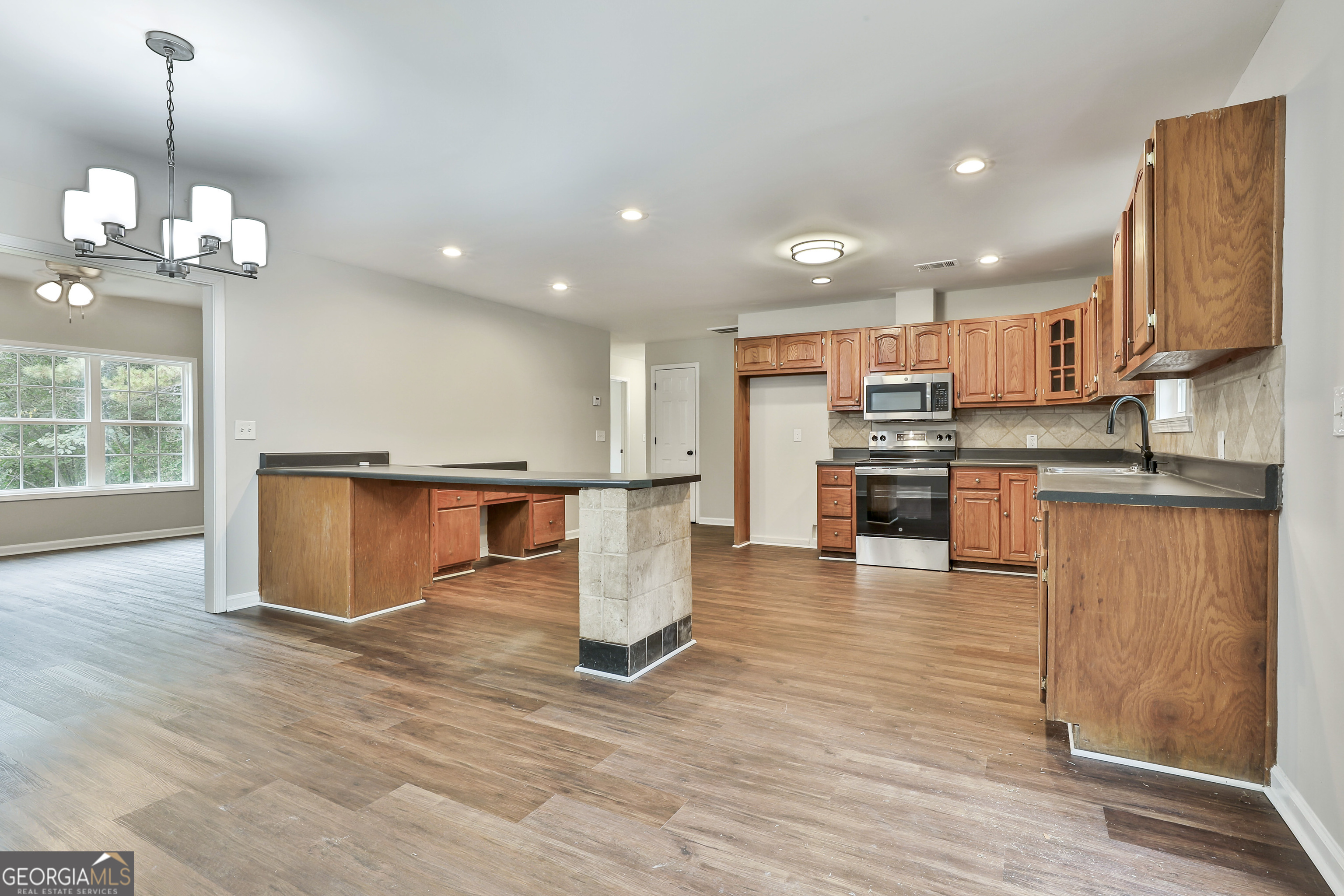 1606 Mcwilliams Barber Road Luthersville, GA 30251 - Photo 18 of 38 a view of a kitchen with kitchen island a counter top space appliances and a ceiling fan