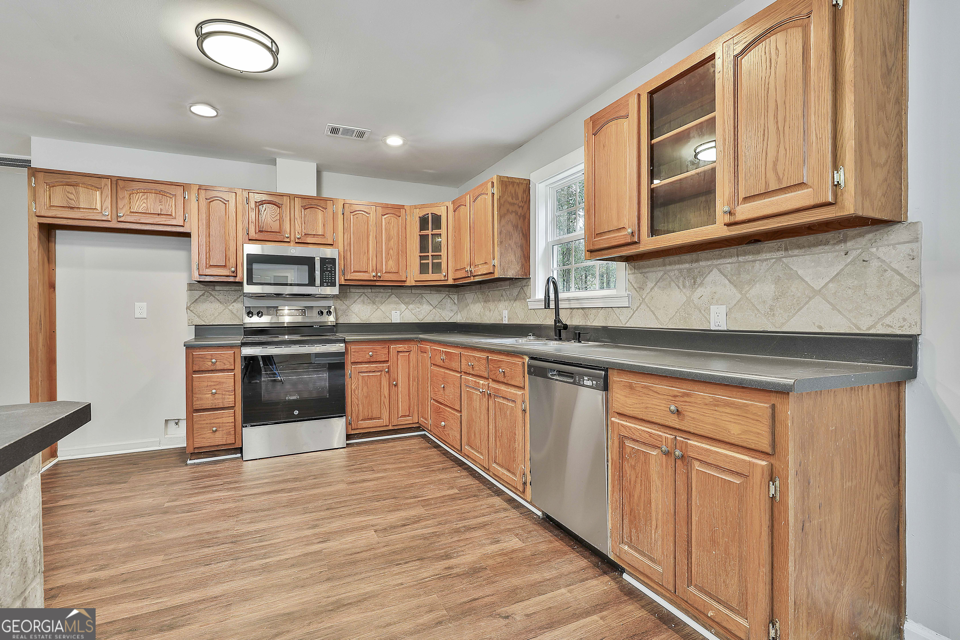 1606 Mcwilliams Barber Road Luthersville, GA 30251 - Photo 19 of 38 a kitchen with stainless steel appliances granite countertop a sink and cabinets