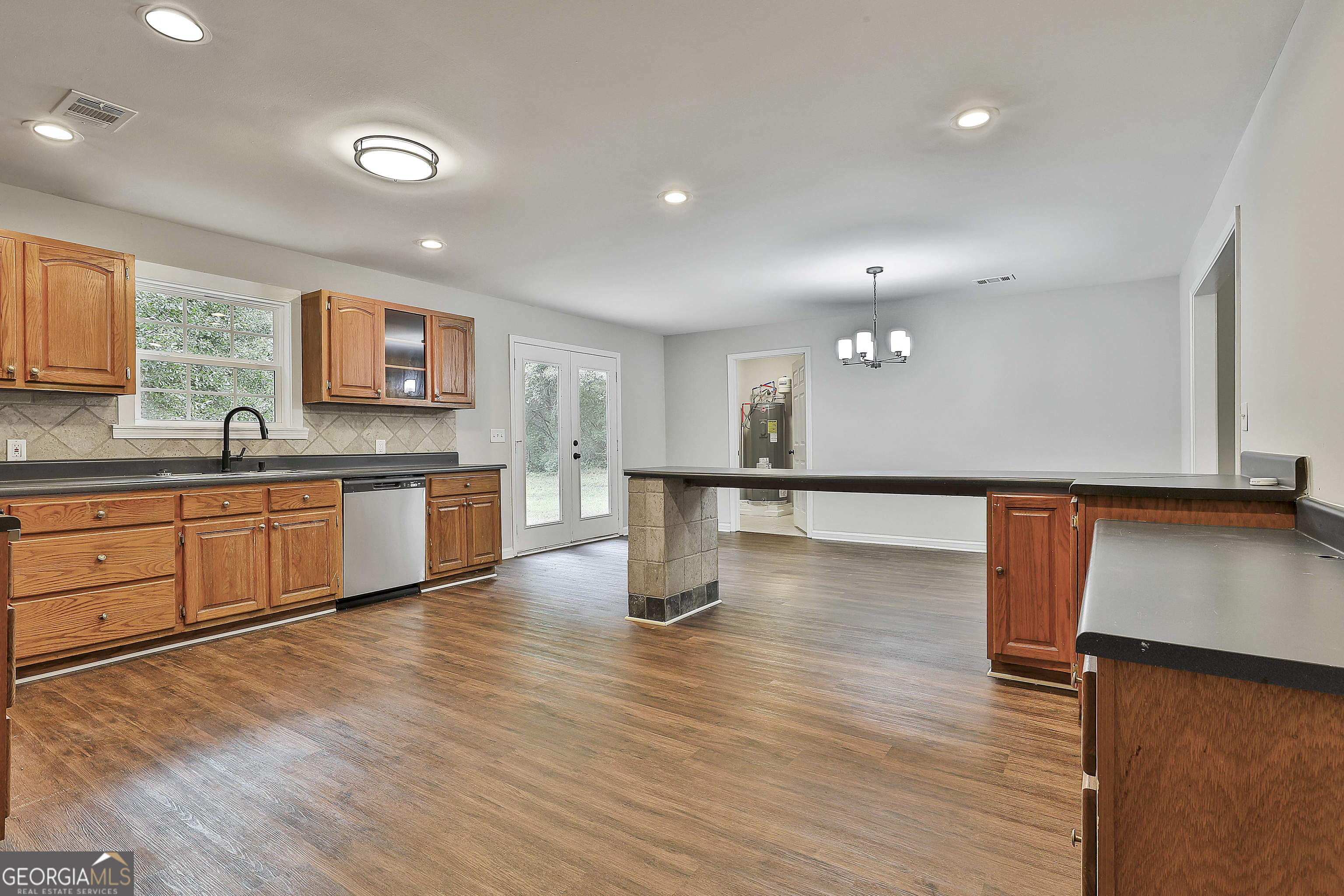 1606 Mcwilliams Barber Road Luthersville, GA 30251 - Photo 21 of 38 a kitchen with stainless steel appliances granite countertop a sink counter space and wooden floor