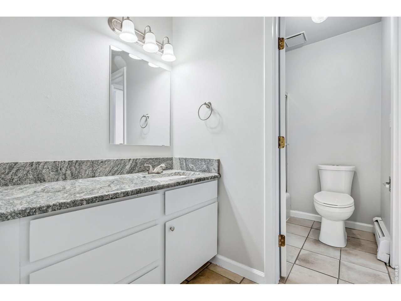 809 East Drake Road, Unit C107 Fort Collins, CO 80525 - Photo 14 of 24 a bathroom with a granite countertop sink a toilet and a mirror