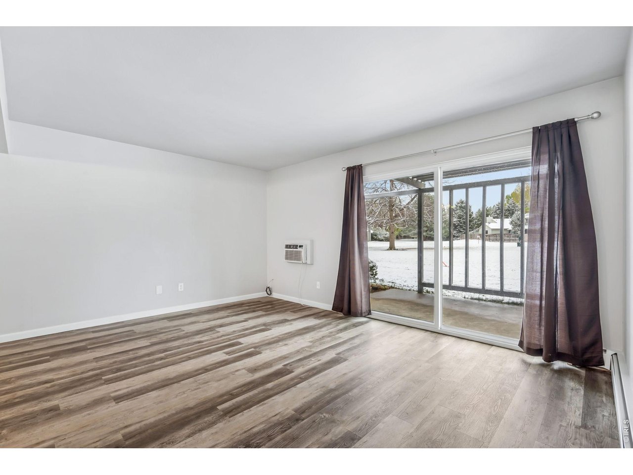 809 East Drake Road, Unit C107 Fort Collins, CO 80525 - Photo 4 of 24 a view of an empty room with wooden floor and a window